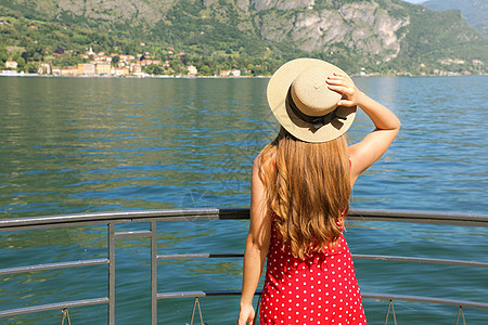 享受科莫湖美景的旅行者女孩 在意大利科莫湖 Bellagio 的露台上放松的年轻女子的后视图图片