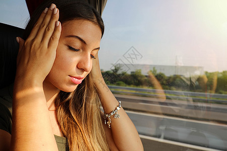 年轻女子在公共汽车旅行期间生病 晕车旅游妇女在公共汽车上头痛或恶心图片