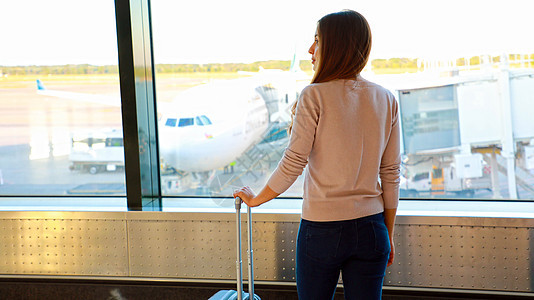 年轻妇女在机场候机时等待飞机起飞图片