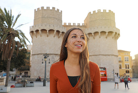 瓦伦西亚旅游 微笑美丽的旅游女孩在巴伦西亚 西班牙 有魅力的年轻女人 背景是托雷斯德塞拉诺斯门图片