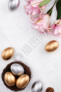 金蛋和银复活节鸡蛋 在巢中与粉红色双莉莉花 春天图片