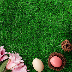 有粉红色双百合百合花的草坪上的巢穴里 藏着多彩的复活节鸡蛋 桌子 叶子图片