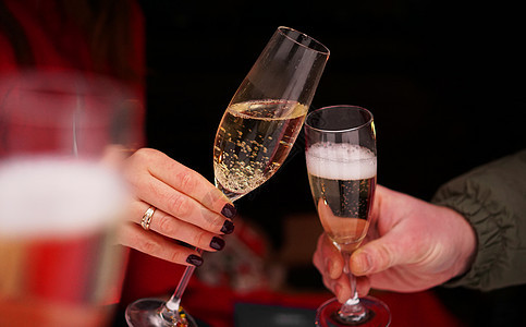 约会概念   关闭男女手中的香槟杯玻璃杯图片