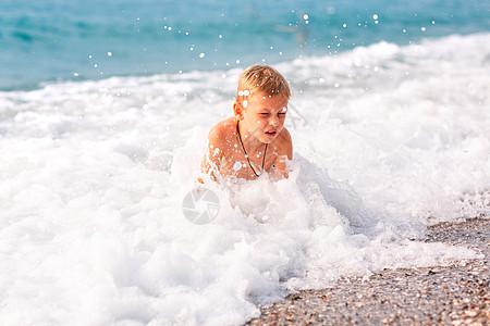 快乐的小男孩 在海边的波浪中玩得开心 海洋图片