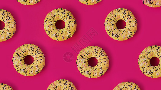 粉红色背景上一排排甜甜圈的节日创意图案 装饰品背景图片