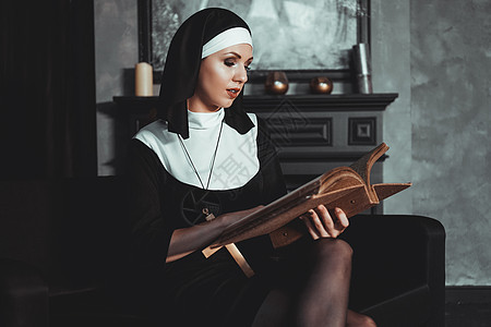 身穿宗教黑西装的美丽的年轻修女持有圣经 宗教概念 兜帽 牧师图片