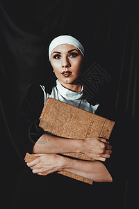 身穿宗教黑西装的美丽的年轻修女持有圣经 宗教概念 女性 拥抱图片