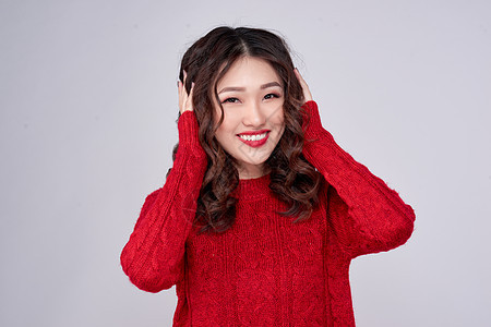 穿红毛衣的亚裔女孩 圣诞节日 她穿着红色丝绒羊毛裙 红色的 白色的图片
