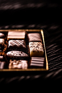 巧克力工厂礼盒中的瑞士巧克力 瑞士巧克力店用黑巧克力和牛奶有机巧克力制成的各种豪华果仁糖 作为节日礼物的甜点食品和高级糖果品牌 平铺 菜单背景