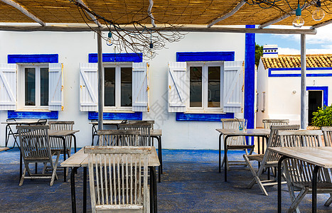 葡萄牙阿尔加维波尔蒂芒海岸附近海滩附近露台上的餐桌和椅子 葡萄牙波尔蒂芒镇附近海景小型沿海餐厅的露台上的桌子图片