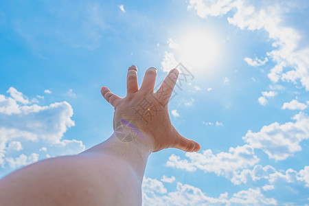 一个试图达到太阳和天堂的人的手图片