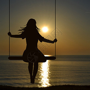 一位年轻女子在海边摇摇欲坠的月光下图片