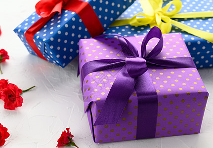 装在节日紫色纸和白色背景带丝绸 生日礼物 惊喜的彩衣盒图片