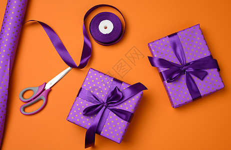 最顶端视图 带有橙色背景的紫丝带的礼品盒装有紫色丝带图片