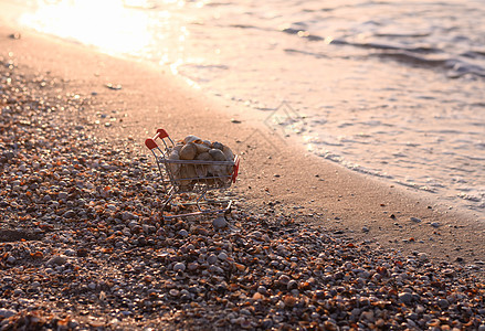 一个超市购物篮 满满的贝壳 在海滩上图片