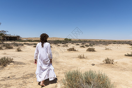一个女人站在沙漠里 看着地平线 白衣在风中飘荡 放松 内心观望 冥想 心灵平静的概念 笑声 沙丘 粮食图片
