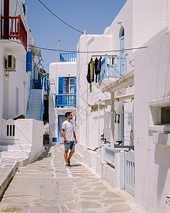 希腊米科诺斯岛 希腊度假期间在米科诺斯老城街道上的年轻人 希腊小威尼斯米科诺斯岛 男人 夏天图片
