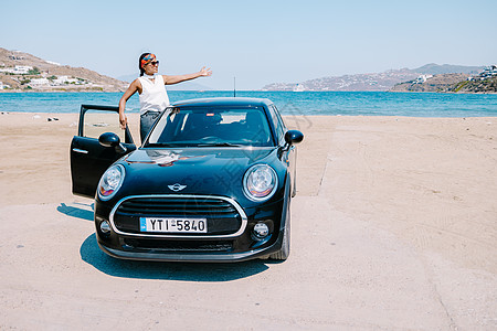 米科诺斯希腊 2018年4月 女性在一次公路旅行中 在Mykonos路上的海滩上的米尼汽车图片