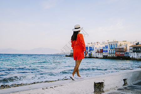 希腊米科诺斯岛 希腊小威尼斯米科诺斯岛度假期间在米科诺斯老城街道上穿着裙子的年轻女子 建筑学 夏天图片