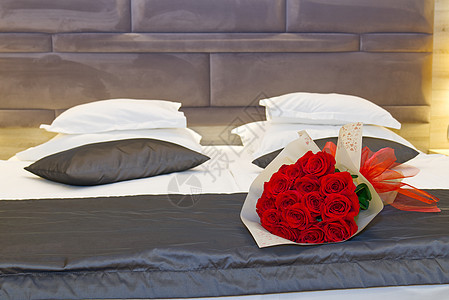 在酒店蜜月房间的床上 盛放红玫瑰 在酒店举行浪漫的客人会议 笑声 枕头 卧室背景图片