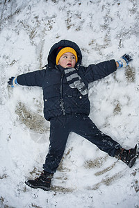 男孩躺在雪中 孩子 衣服 美丽的 脸 活动 帽子 男生图片