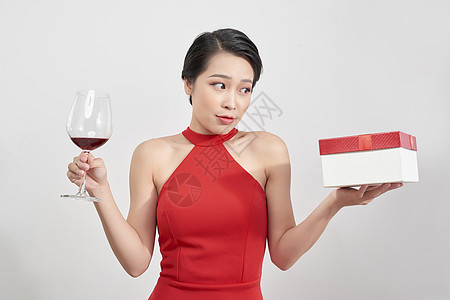 与工作室背景隔绝的美丽模特肖像 握着葡萄酒杯和圣诞礼物 Y 我 图片