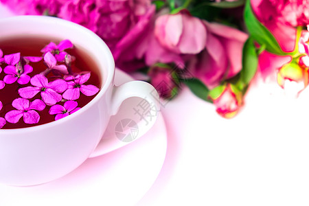 明亮的桌子上有粉色牡丹花和一杯茶的创意布局 春季季节性情人节 女人 母亲 3 月 8 日假期 浪漫早餐 时尚博主 问候卡 邀请函图片