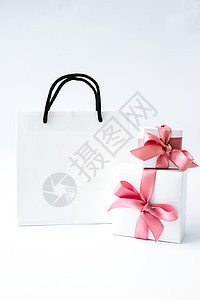 空白纸白色袋子和两个礼品盒 白色背景上有粉色丝带 黑色星期五销售 购物概念 纸质购物袋样机 盒子 礼物盒图片