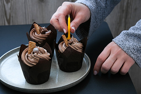 女性亲手制作美味巧克力蛋糕 奶油夹在黑暗背景上 三份巧克力松饼 生日蛋糕晚会的准备 派对 派对食物图片