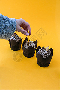 女性亲手制作美味巧克力蛋糕 奶油加黄底的乳霜 三份巧克力松饼 生日蛋糕晚会准备 食物 甜的图片