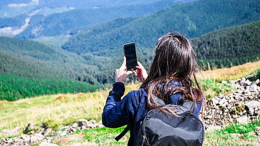 无脸少女在山中拍照 登山的女博主的背影 旅游旅行女孩在山上旅行的冒险图片