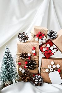 零浪费圣诞礼物 配有香槟彩色丝绸背景的装饰品 复制空间 生态友好 包装礼品和手工艺纸板标签 新年 树图片