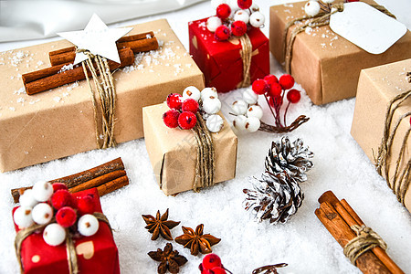 零浪费圣诞礼物与白雪背景上的装饰品 复制空间 带有工艺纸板标签的环保包装礼品 手工制作的 平躺图片