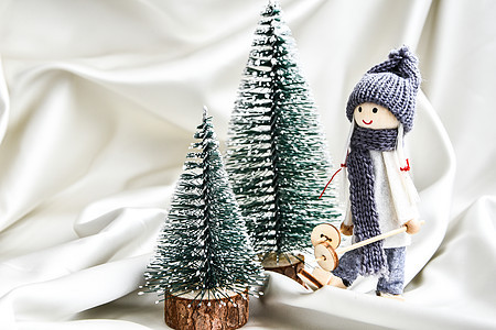圣诞节配有玩偶滑雪以及丝绸 圣诞或新年贺卡上的风树节庆装饰品 丝缎 织物背景图片