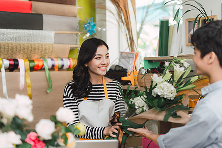 人 购物 销售 花艺和消费主义概念-快乐微笑的花店女人为花店的男人或顾客制作花束图片