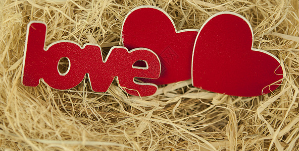 两颗心在干草中的形象作为爱情的象征 close-u 情人节 木头图片