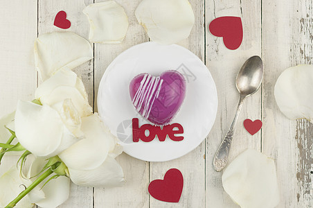爱和白花瓣玫瑰 红蛋糕以心脏的形状呈现在桌子上 浪漫的约会 天 念日图片
