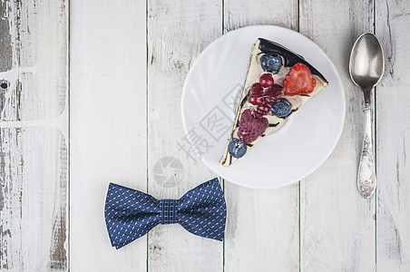 蓝莓切片方蛋糕白色盘子上混合白莓切片蛋糕 木本领带上的弓领 快乐父亲节 蓝莓 黑莓背景