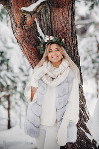 在寒冷的冬天森林里穿着白色皮草大衣的女人的画像 在白雪覆盖的冬季森林里 头戴花环的女孩 皮毛大衣 街道图片