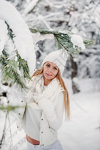 一个穿着白色衣服的女人在寒冷的冬天森林里的画像 在白雪皑皑的冬季森林里 一个头戴白帽子的女孩 长的 新年快乐图片