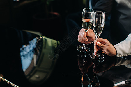 一个男人和一个女人手握着香槟杯 紧紧地放在手上 酒吧 女性图片