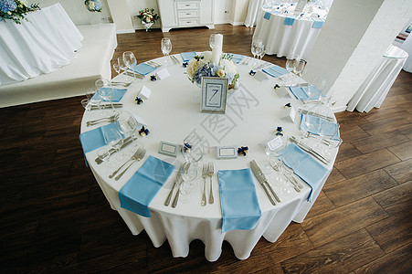 节庆桌用浅色的彩色装饰 配有蓝色餐巾纸和鲜花 没有食物 餐厅 灰蓝色图片