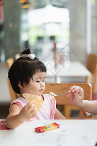 可爱的婴儿在餐厅餐桌上吃冰淇淋 饥饿的 家 艺术图片
