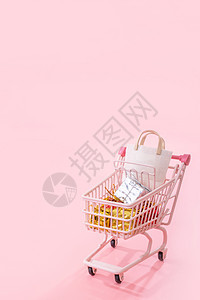 年度销售购物季概念 — 迷你粉色购物车手推车 里面装满纸袋礼物 与淡粉色背景隔离空白复制空间关闭 u 大车 新年图片