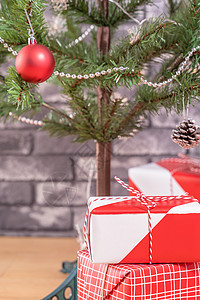 装饰圣诞树 家里有包着美丽的红白礼物 黑砖墙 喜庆设计概念 关门了 笑声 地面 新年图片