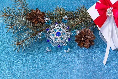 蓝色闪亮背景上的圣诞元素布局 云杉树枝锥和水晶雪花 浪漫的 装饰风格图片