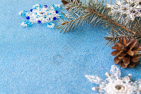 蓝色闪亮背景上的圣诞元素布局 云杉树枝锥和水晶雪花 美丽的 快乐的图片