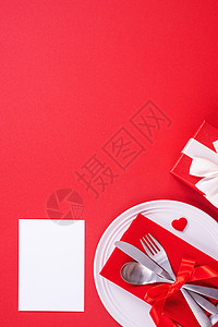 情人节日餐具设计构想 - 浪漫板盘菜在红背景上被隔绝 用于餐厅 庆祝节日宣传 顶级观景 平铺 刀 餐巾图片