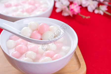 汤圆 汤圆 红色背景的小碗里放着美味的红白汤圆 中国冬至节的亚洲节日食品 特写 大理石 桌子图片