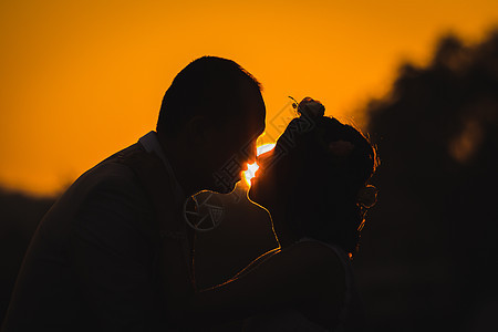 浪漫情侣拥抱着日落的月光背景图片